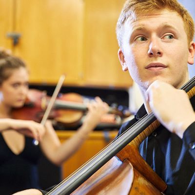 Guildhall students practicing playing the violin and cello